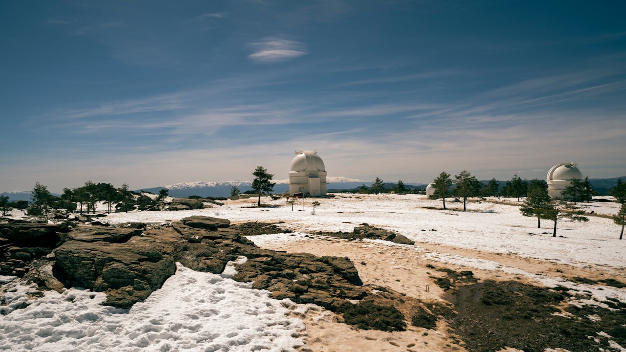 The Art of Drawing Readers In: Your attractive post title goes here A breathtaking view of snow-covered observatories on a rocky plain under a clear blue sky.
