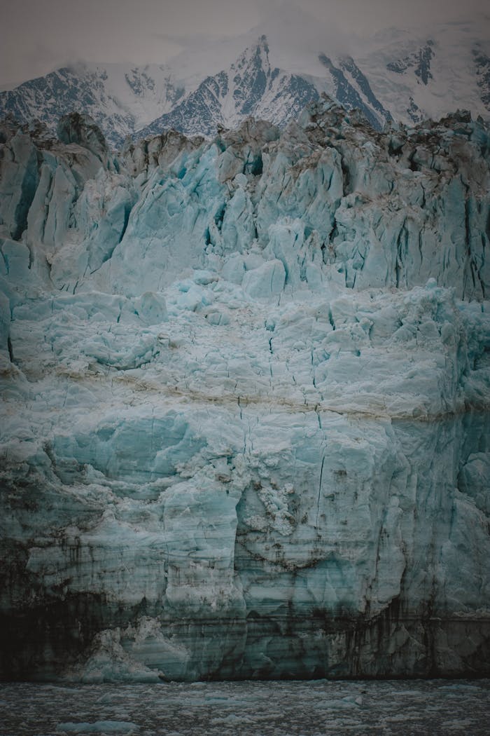 about-img-01 A breathtaking view of a towering glacier ice wall in an arctic landscape highlighting climate change.